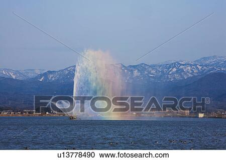 Fountain in Lake Making Rainbow, Snowcapped Mountains in the Background View Large Photo Image Stock Image - Fountain in Lake Making Rainbow, Snowcapped Mountains in the Background. Fotosearch