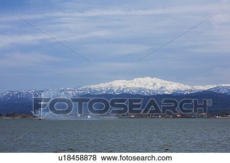 Fountain in Lake, Snowcapped Mountains in the Background View Large Photo Image Stock Photo - Fountain in Lake, Snowcapped Mountains in the Background. Fotosearch