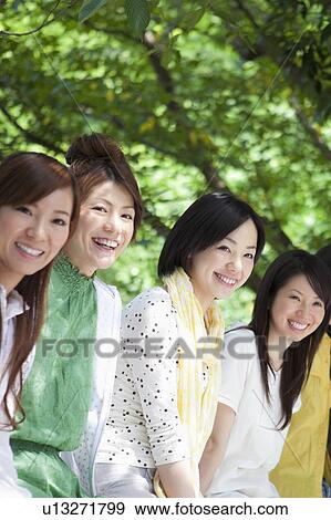 Stock Photo - Four Young Women Sitting Outdoors. Fotosearch