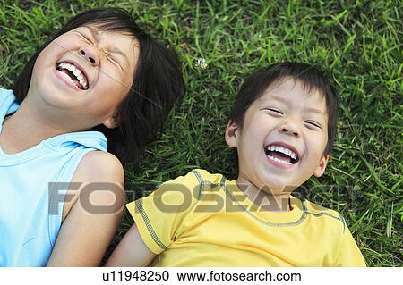 Girl and Boy Laughing and Lying on Grass View Large Photo Image Stock Image - Girl and Boy Laughing and Lying on Grass. Fotosearch