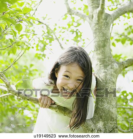 Stock Image - Girl Climbing Tree. Fotosearch