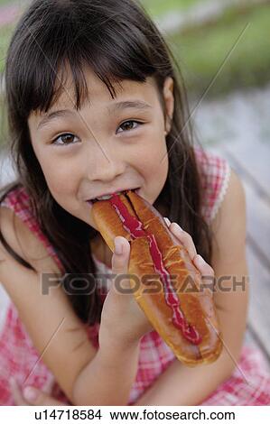 Picture - Girl Eating Hot Dog. Fotosearch
