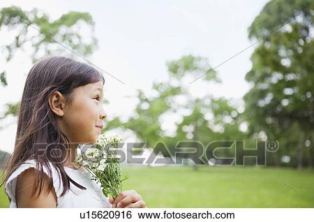 Stock Photograph - Girl Holding Bunch of Wildflowers. Fotosearch