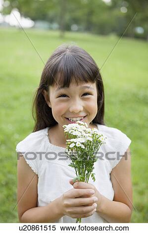Stock Photography - Girl Holding Bunch of Wildflowers. Fotosearch