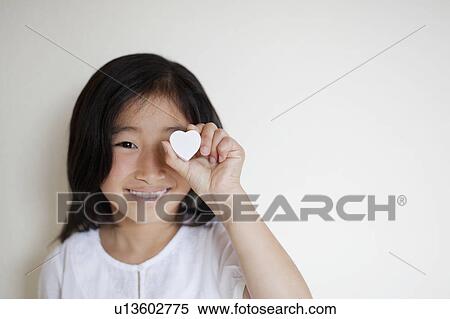 Girl Holding Love Heart in Front of her Eye View Large Photo Image Stock Photography - Girl Holding Love Heart in Front of her Eye. Fotosearch