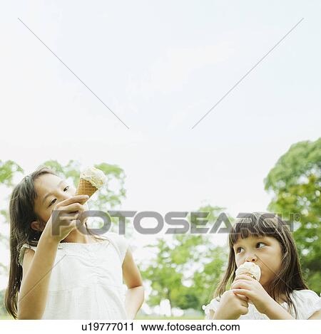 Stock Image - Girls Eating Ice Creams. Fotosearch
