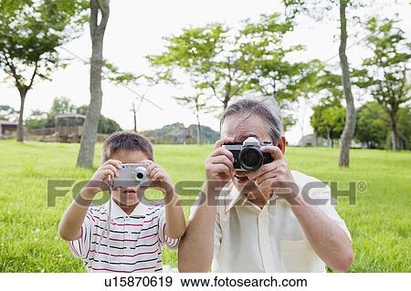 Stock Photo - Grandfather and Grandson Taking Photos. Fotosearch