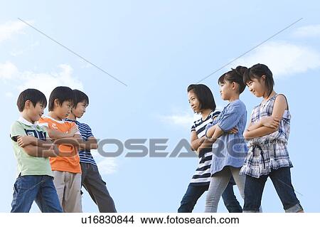 Groups of boys and girls looking at each others, arms crossed View Large Photo Image Picture - Groups of boys and girls looking at each others, arms crossed. Fotosearch