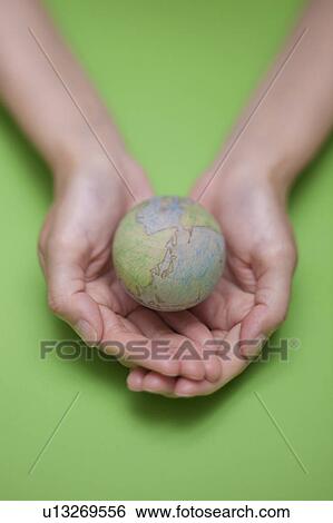 Stock Photograph - Hand Holding Wooden Globe. Fotosearch