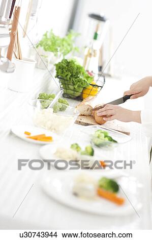 Picture - Hands cutting baguette. Fotosearch
