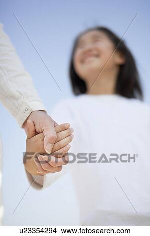 Picture - Low Angle View of Mother and Daughter Holding Hands. Fotosearch