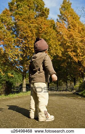 Stock Photo - Low Angle View of Young Boy in Park. Fotosearch