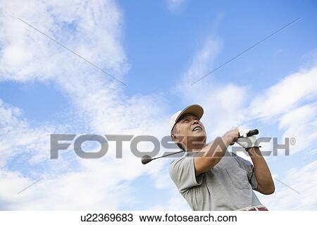 Stock Image - Mature Golf Player Against Sky. Fotosearch