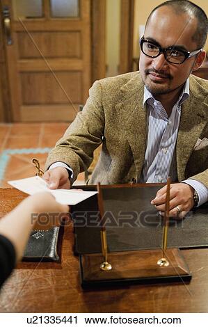 Stock Image - Mature Man Passing Document. Fotosearch