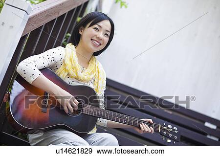 Stock Photo - Mid Adult Woman Playing Guitar. Fotosearch