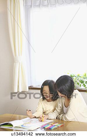 Stock Image - Mother and daughter coloring indoors. Fotosearch