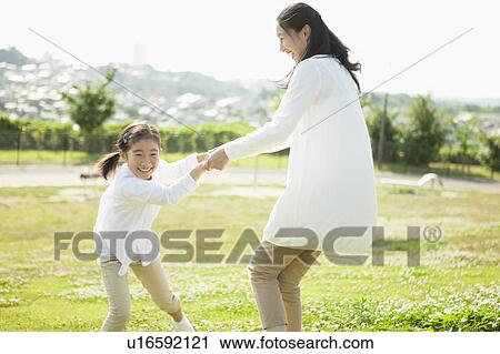 Stock Image - Mother and Daughter Playing in Field. Fotosearch