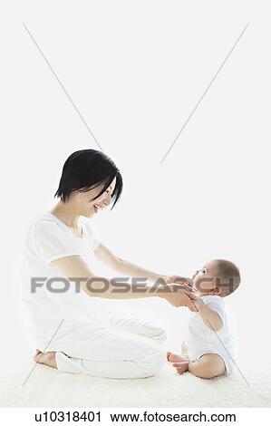 Stock Image - Mother Holding Baby Boy's Hands. Fotosearch