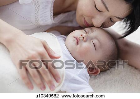 Stock Image - Mother Holding Sleeping Baby Boy Gently. Fotosearch
