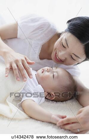 Stock Photo - Mother Watching Baby Boy Sleeping. Fotosearch