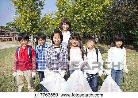 Portrait of school children and female teacher holding bags for recycling View Large Photo Image Stock Image - Portrait of school children and female teacher holding bags for recycling. Fotosearch
