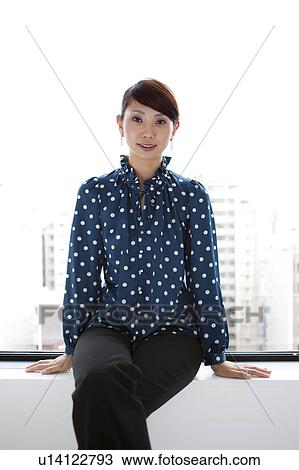 Portrait of young woman sitting on window sill, smiling View Large Photo Image Stock Image - Portrait of young woman sitting on window sill, smiling. Fotosearch