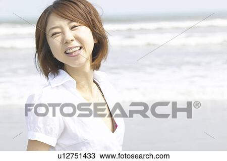 Portrait of young woman smiling at beach View Large Photo Image Stock Image - Portrait of young woman smiling at beach. Fotosearch