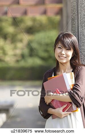 Stock Photography - Portrait of young woman smiling, Japan. Fotosearch