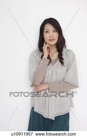 Portrait of young woman, smiling, white background View Large Photo Image Stock Photo - Portrait of young woman, smiling, white background. Fotosearch