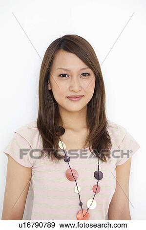 Stock Photo - Portrait of young woman, smiling, white background. Fotosearch