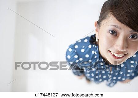 Stock Photo - Portrait of young woman, smiling, white background, copy space. Fotosearch