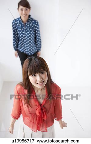 Stock Photo - Portrait of young women, smiling, white background. Fotosearch