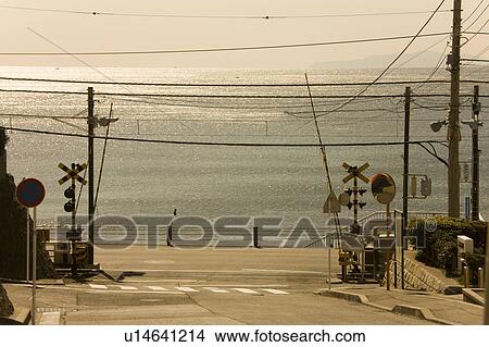 Picture - Railroad crossing and sea, Kanagawa Prefecture, Honshu, Japan. Fotosearch