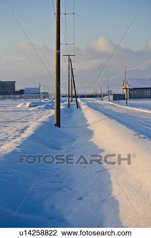 Stock Image - Row of Utility Poles Beside Rural Road in Winter. Fotosearch