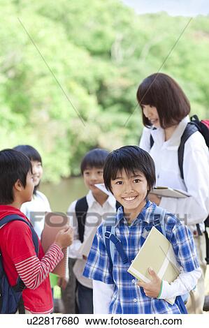 School children and female teacher in park, boy looking at camera View Large Photo Image Stock Image - School children and female teacher in park, boy looking at camera. Fotosearch