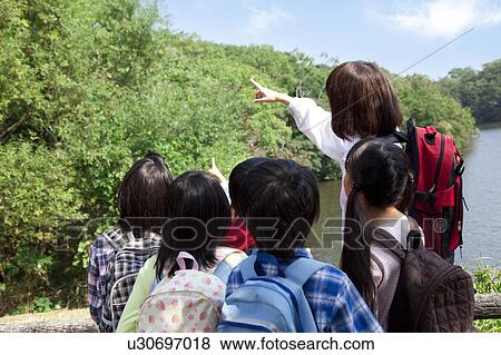 School children and female teacher in park View Large Photo Image Stock Photo - School children and female teacher in park. Fotosearch