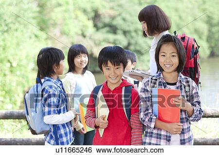 School children and female teacher in park, two students looking at camera View Large Photo Image Stock Photograph - School children and female teacher in park, two students looking at camera. Fotosearch