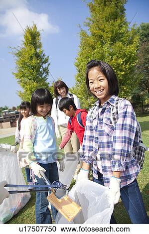 Stock Image - School children picking garbage in park. Fotosearch