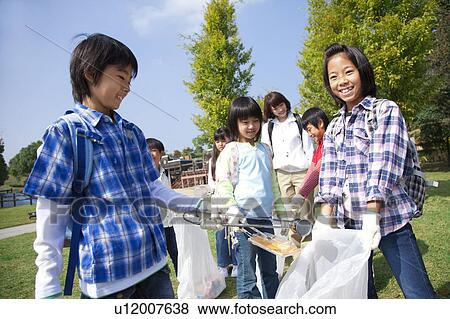 Stock Photo - School children picking garbage in park. Fotosearch