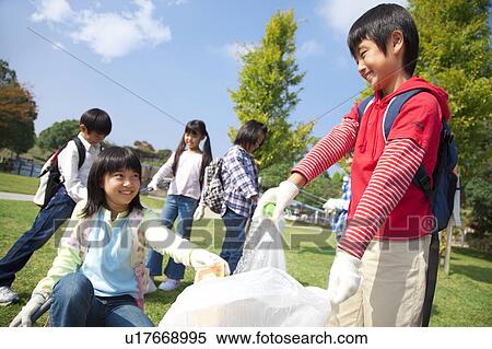 Stock Photography - School children picking garbage in park. Fotosearch