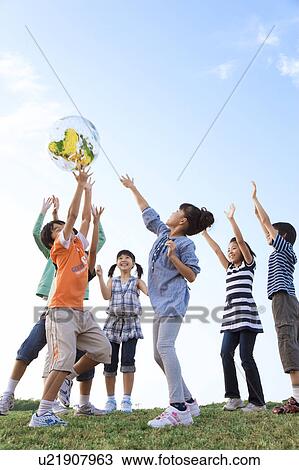 School children with female teacher playing with globe View Large Photo Image Stock Image - School children with female teacher playing with globe. Fotosearch