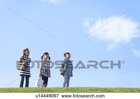 Schoolgirls standing at riverbank, looking away, copy space View Large Photo Image Stock Photo - Schoolgirls standing at riverbank, looking away, copy space. Fotosearch