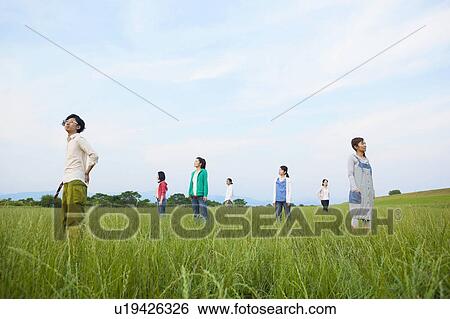 Stock Photograph - Seven Young Men and Women Standing in Field. Fotosearch