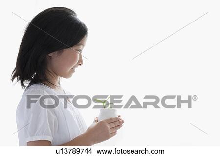 Picture - Side View of Young Girl Holding Potted Sprout. Fotosearch