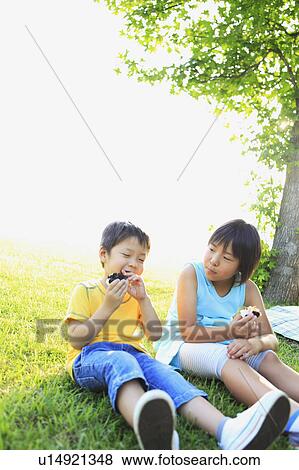 Sister and Brother Eating Snack in Park View Large Photo Image Stock Photo - Sister and Brother Eating Snack in Park. Fotosearch