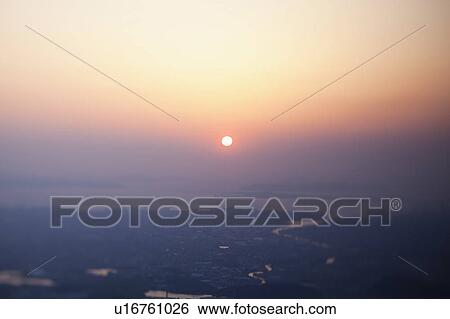 Stock Photograph - Sun Setting Over Sea in Sasaguri. Fotosearch
