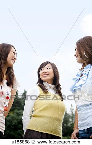 Stock Image - Three young women smiling, copy space. Fotosearch