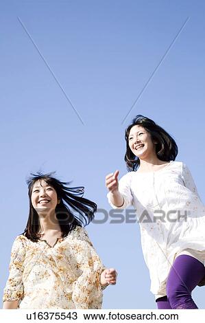 Tow Young Women Running Under Blue Sky View Large Photo Image Stock Image - Tow Young Women Running Under Blue Sky. Fotosearch