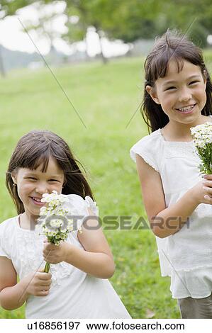 Stock Photo - Two Girls Holding Bunch of Flowers. Fotosearch
