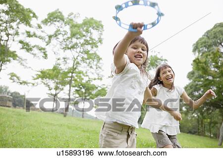Stock Photograph - Two Girls Playing Tambourines. Fotosearch